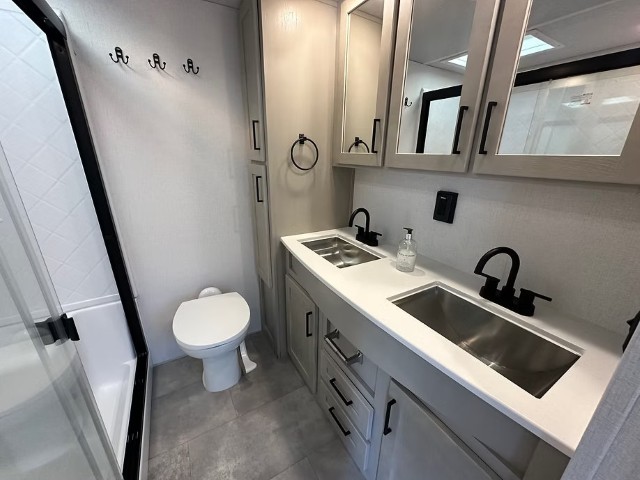 Bathroom with enclosed shower, WC and double vanity with two sinks