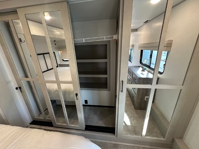 Full-width mirrored sliding wardrobe in fifth wheel bedroom