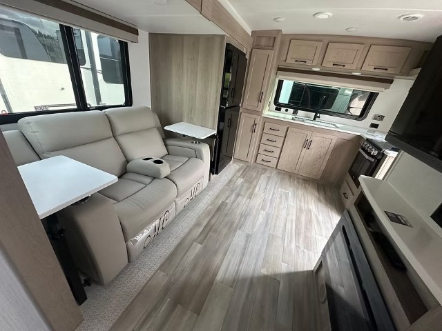 Reclining lounge seating with fold-out tray tables inside accommodation unit