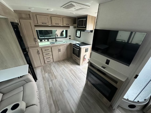 Kitchen, large TV and lounge area inside Rapid Rehouse accommodation unit