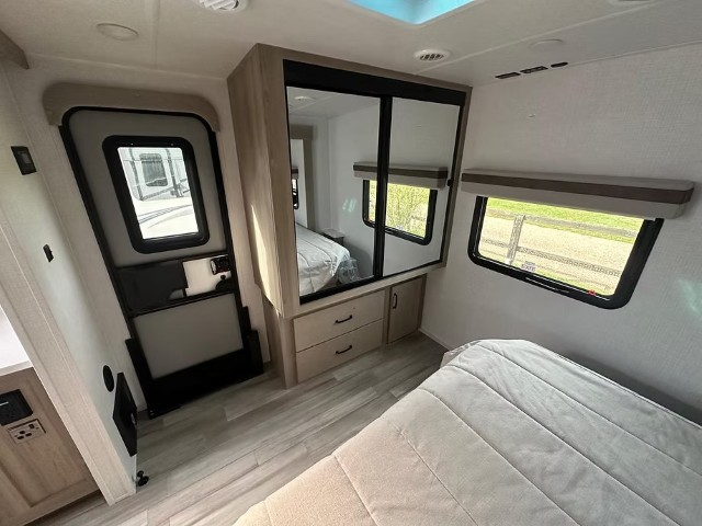 Bedroom storage area with sliding mirror wardrobe and under-bed drawers