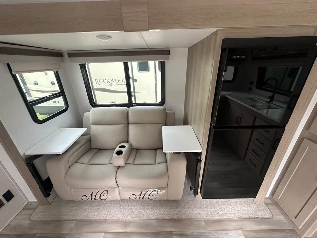 Reclining sofa lounge area with integrated kitchen and entrance beyond